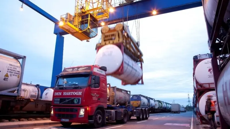 A truck being loaded with freight from a crane