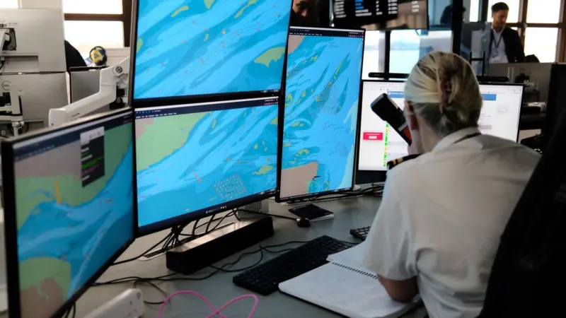 The image shows an operator seated in front of the Kongsberg Maritime VTS