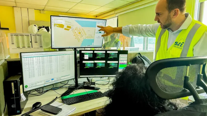 The image shows operators using the digital twinning system at STI