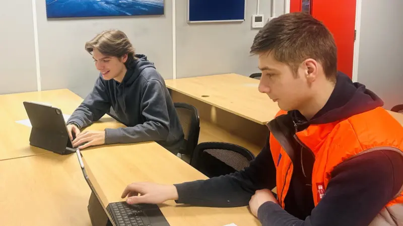 Two Peel Ports apprentices working on computers
