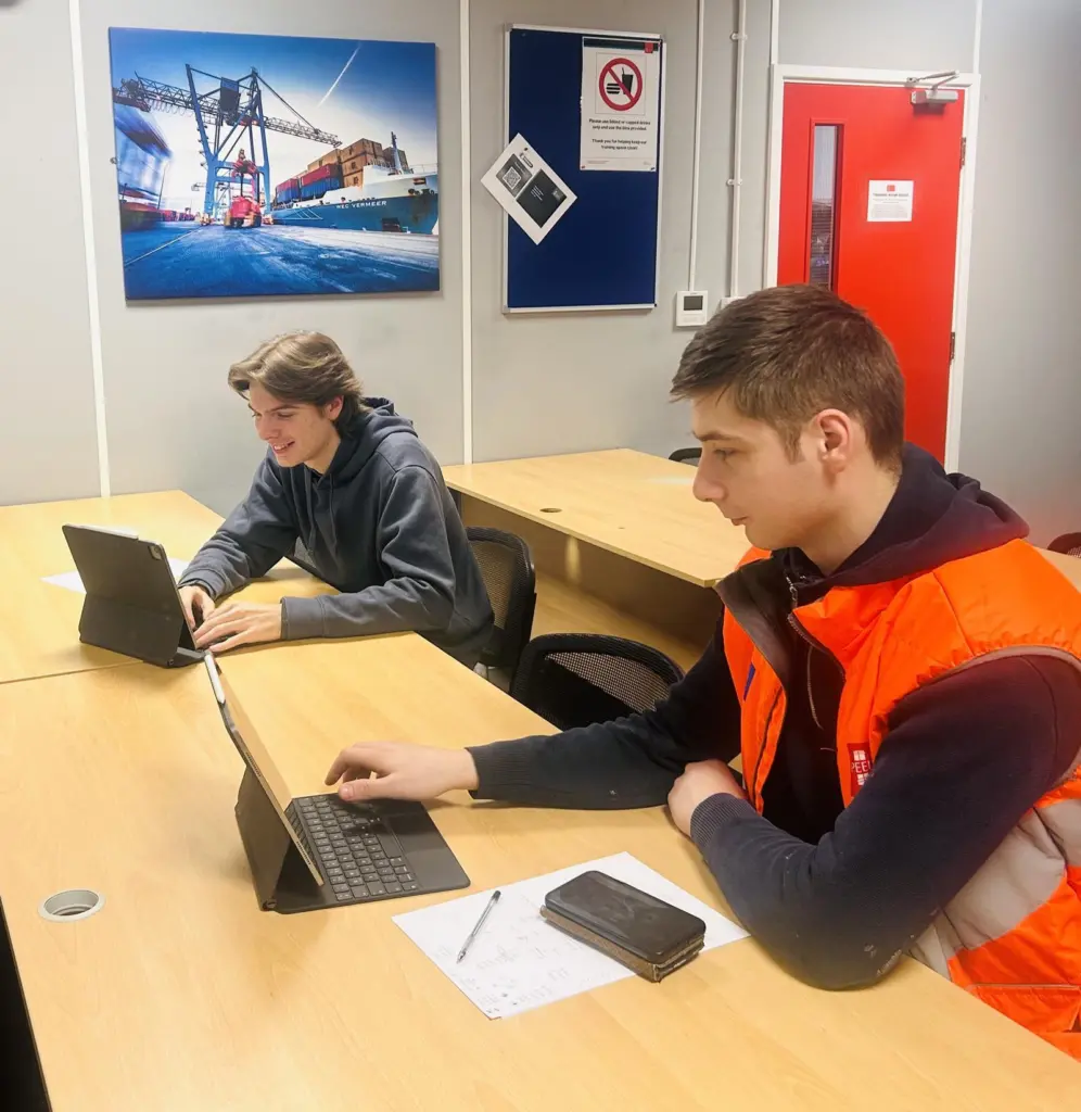 Two Peel Ports apprentices working on computers