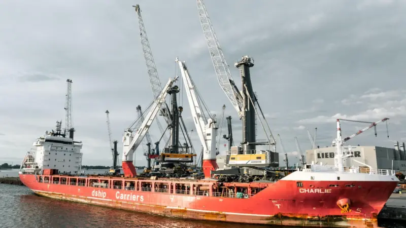 Liebherr ship-to-shore crane by a small container ship dockside