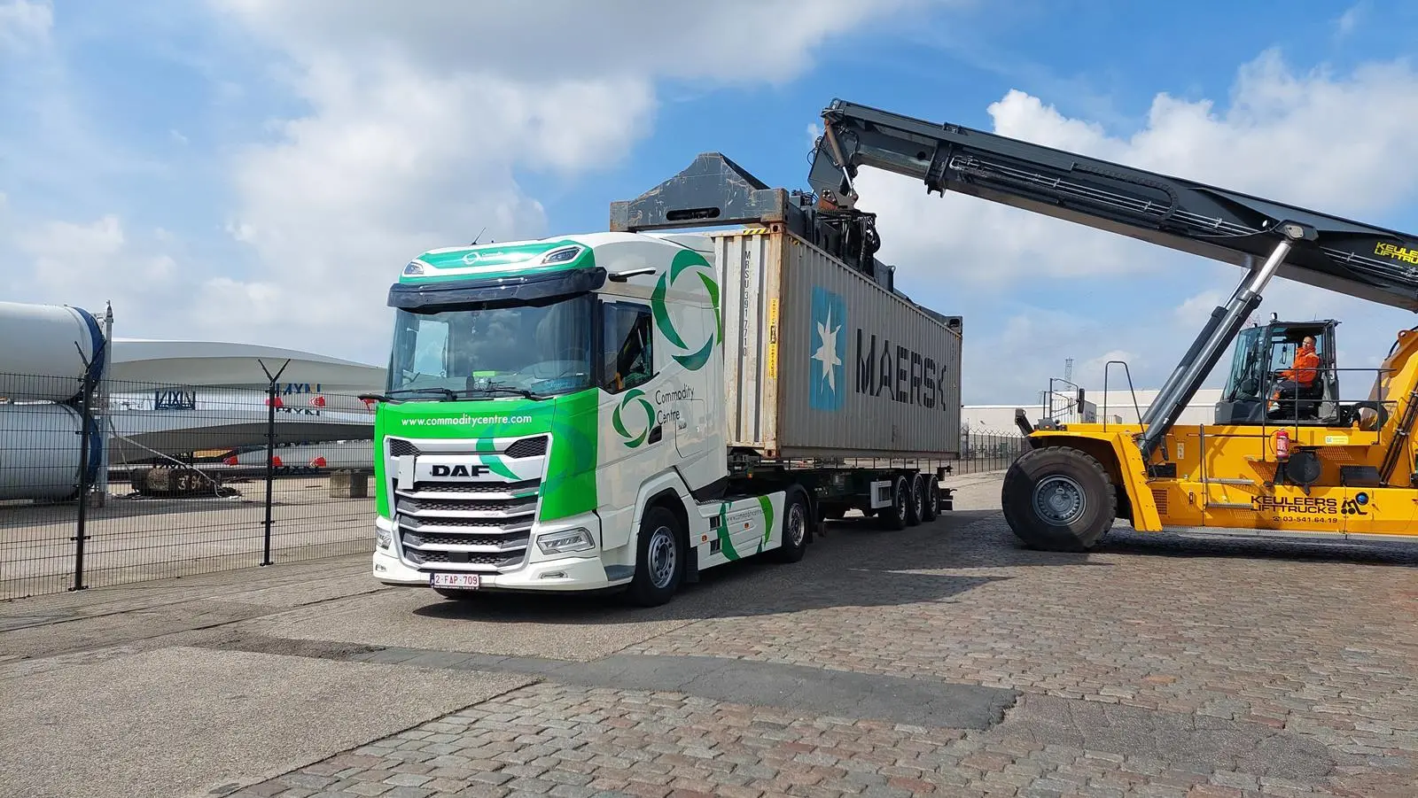 Truck with Maersk container being lifted off by a forklift